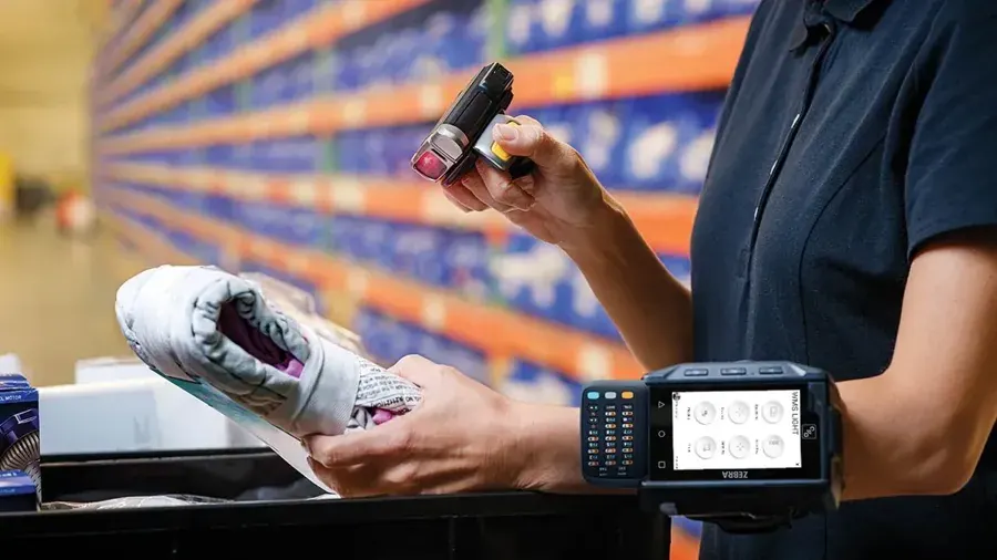 Store worker scanning a shoe with a wearable ring scanner